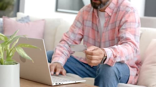 Man Uses Laptop With Credit Card at Home