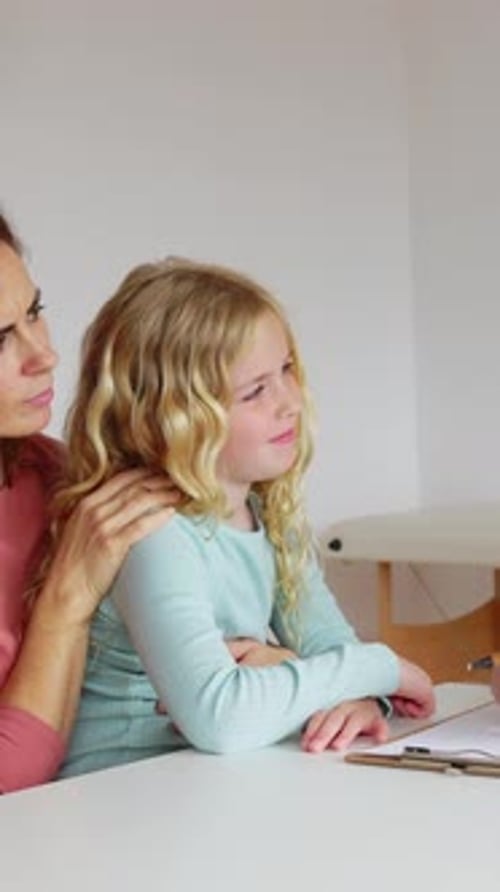 Pediatrician Talking with Mother and Child Girl at Doctor's Office