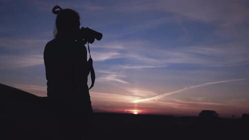 Silhouette of Person with Camera at Sunrise