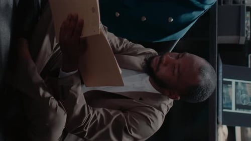 Man Reads Documents at Desk in Office