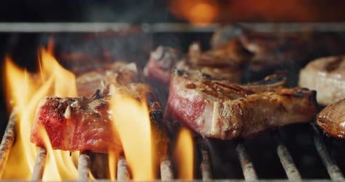 closeup of meat on the grill of a barbeque cooking on a high flame. Concept: Friends, holiday, tra