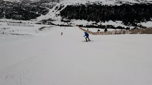 Skier Skiing Downhill on Snowy Mountain Slope