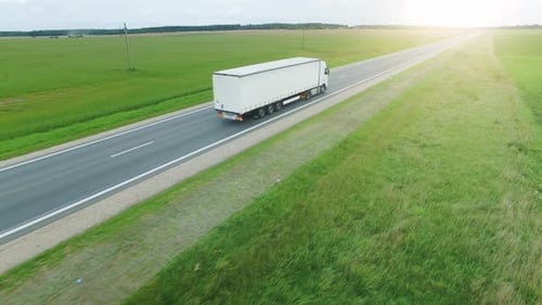 Aerial Shot of a Picturesque Highway Road and Trucks Driving on It.