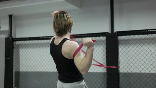 Man Exercising with a Resistance Band in Gym