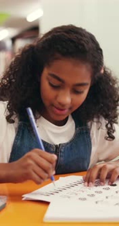 Girl, student and writing with pencil for education, learning or childhood development in library