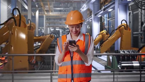 Woman Using Smartphone in Modern Factory Setting