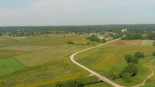 Aerial view white small car. car on an asphalt road with a beautiful landscape. footage. Drone