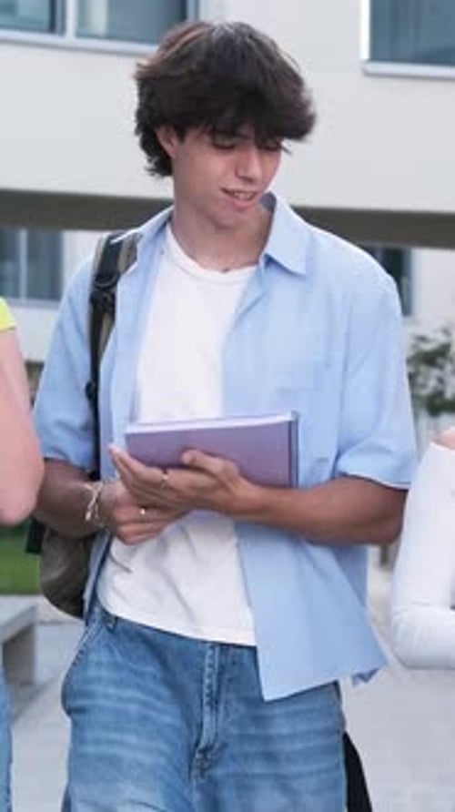 Joyful Student Walking and Laughing with Friends on Campus