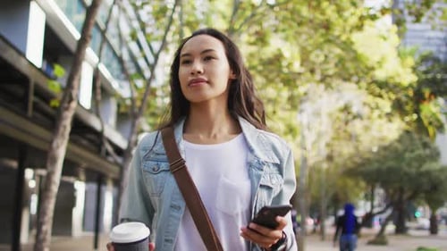 Young Woman Walking with Phone and Coffee