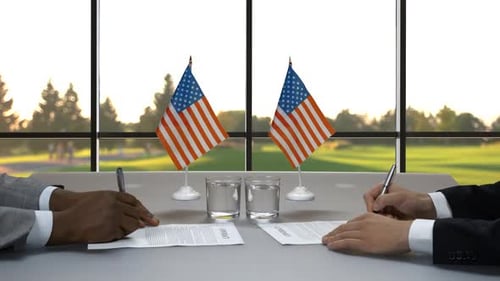 Business People Signing Contract Across From Each Other