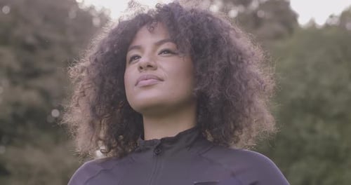 Smiling Woman with Curly Hair in Park