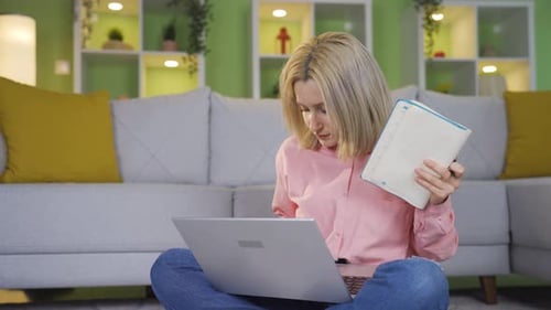 Home office worker young woman sitting on the floor and doing work.