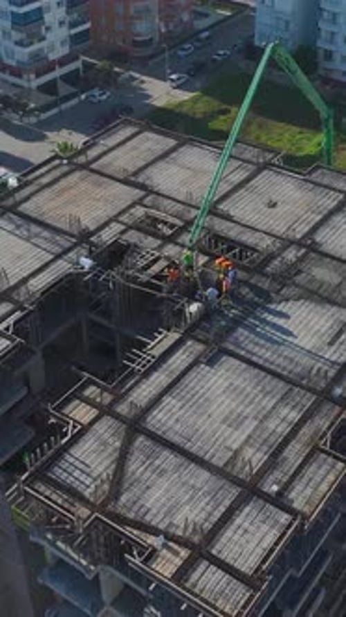 Vertical Video of Engineers Supervising Workers Installing Structural Beams and Pouring Concrete