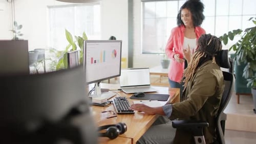 Busy diverse casual business colleagues using computer and discussing work in office, slow motion