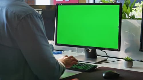 Unknown Freelancer Working Green Screen Computer in Modern Workplace Closeup