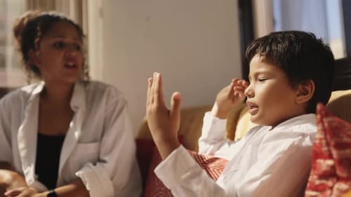 Woman and Boy Talking on Sofa in Home