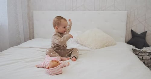 Adorable Infant Playing with Doll on Bed