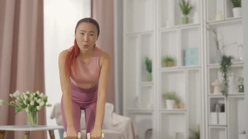Woman Exercising with Dumbbells in Her Home