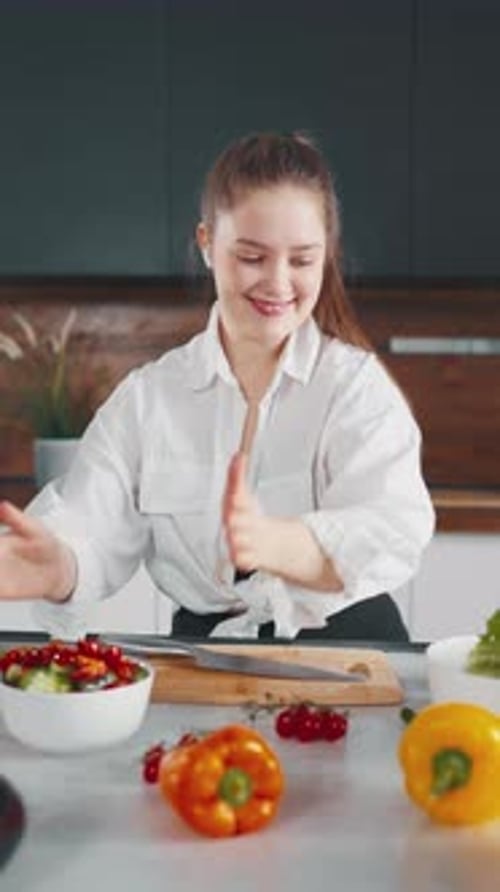 Happy Woman Preparing Salad in Kitchen at Home