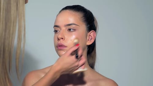 Professional Makeup Artist Working with Beautiful Young Woman Close Up Makeup for Young Model Makeup