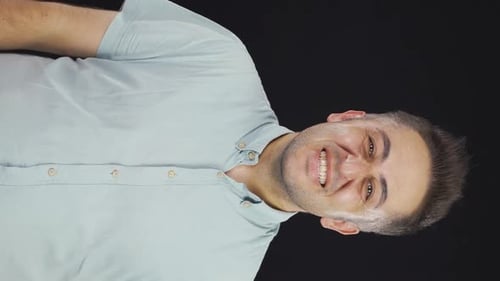 Man Smiles and Clenches Fists Against Black