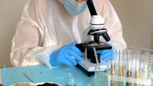Scientist Analyzing Samples with Microscope in Laboratory
