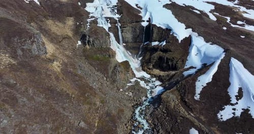 Aerial View of Waterfall in Snowy Mountains