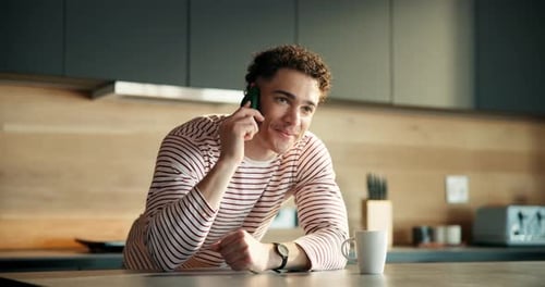 Man Talking on Phone in Bright Modern Kitchen