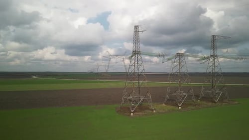 Aerial View of Power Lines Over Green Agricultural Field