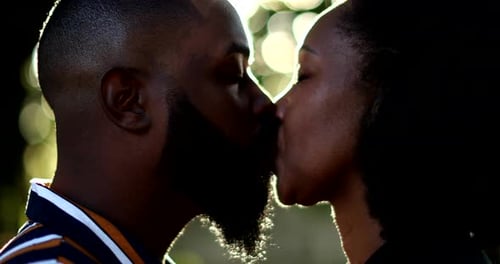 Romantic Couple Shares Tender Kiss in Golden Sunlight