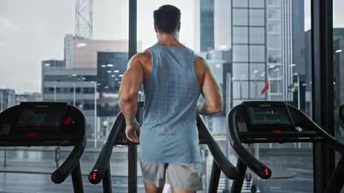 Athletic man working out on a treadmill indoors