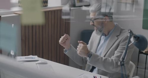 Excited Man Typing At Computer In Office
