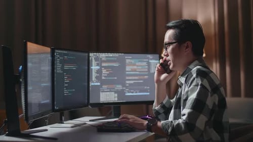 Programmeur asiatique parlant sur un smartphone tout en créant un ingénieur logiciel développant une Appli, un programme