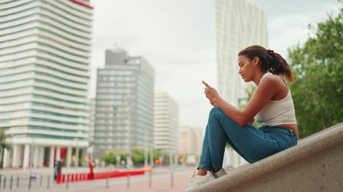 Woman wearing white top is using smartphone on city landscape background