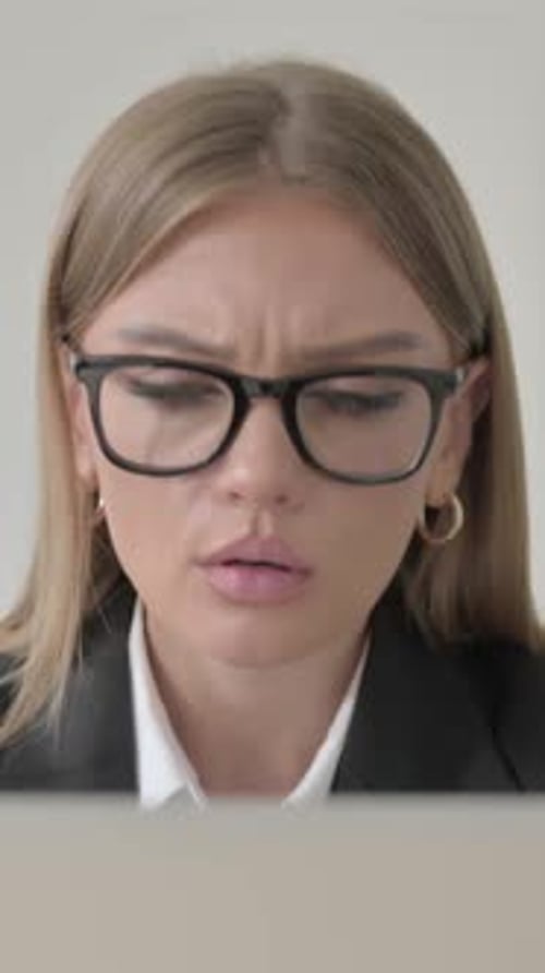 Nahaufnahme einer jungen Geschäftsfrau, die auf einem Laptop auf einen Verlust reagiert, vertikales Video