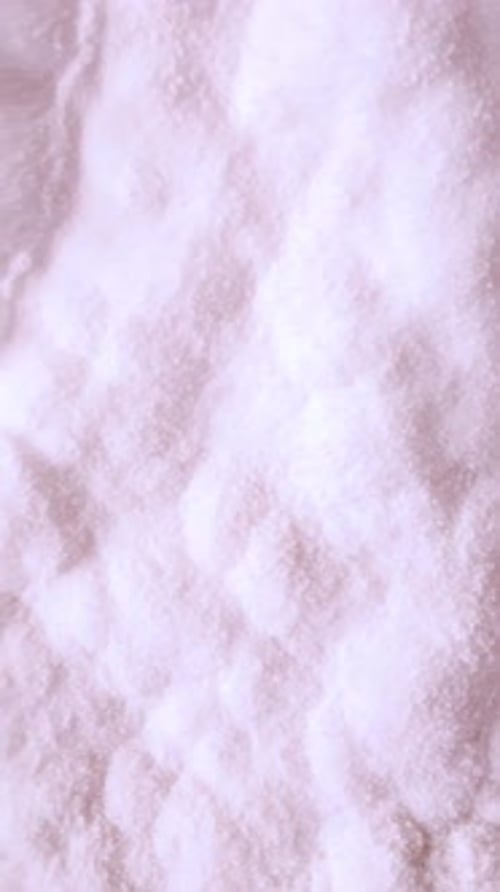 White Salt Crystals Moving in a Slow Ripple