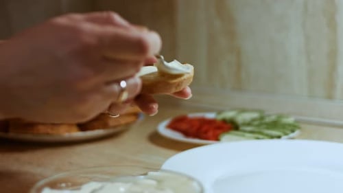Woman Spreading Cream Cheese on Toast at Home