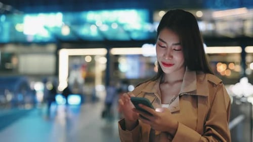 Charming Woman Stands in the Middle of Street and Scrolls Through Her Phone Scrolling Through Photos