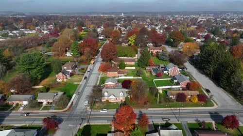 Pennsylvania USA town in autumn. Aerial of car on road driving through residential housing area.