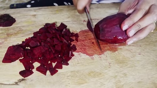 Sauberes Kochen. Frau schneidet frische Rote Beete mit Schutzhandschuhen, Nahaufnahme