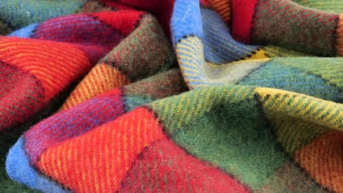 Top view of the soft folds of the bright textured multicolored wool fabric rotated