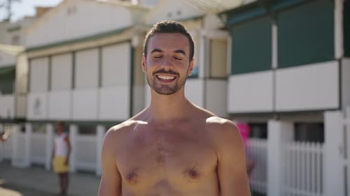 Young Caucasian Handsome Man in Swimwear Smiling at Camera on Sunny Summer Day at Beach