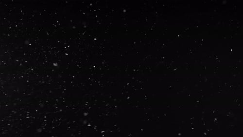 In der Luft schwebende Schneeteilchen Schwarzer Hintergrund