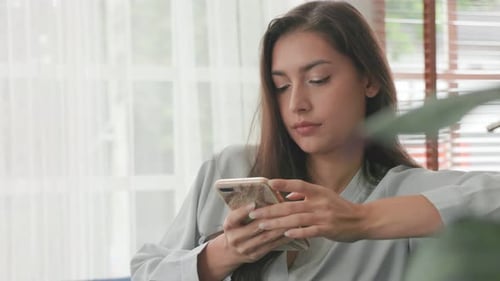 Woman Using Phone Indoors During the Day