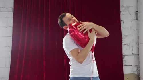 Young Adult Embracing a Red Heart Balloon