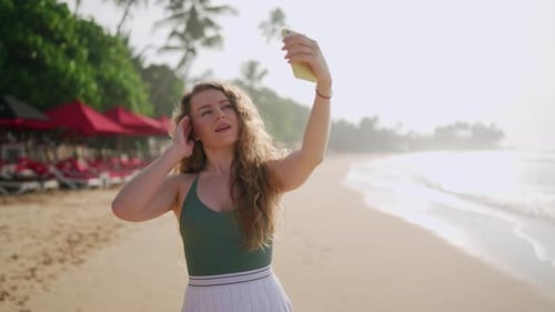 Young Lady Takes Selfie on Tropical Beach at Sunrise Female Adjusts Hair Smiles for Smartphone