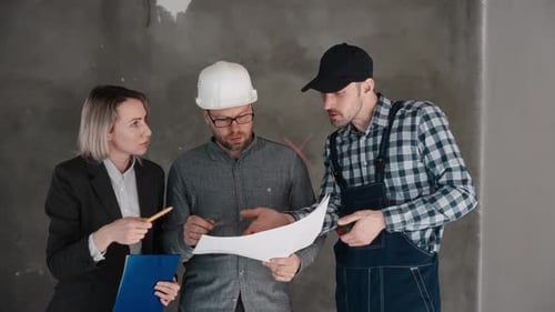 Team Discussing Construction Plans on Paper