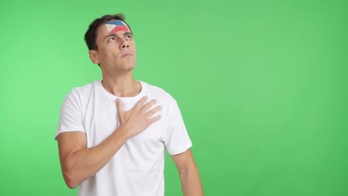 Man Listening to the Philippines National Anthem with Solemnity