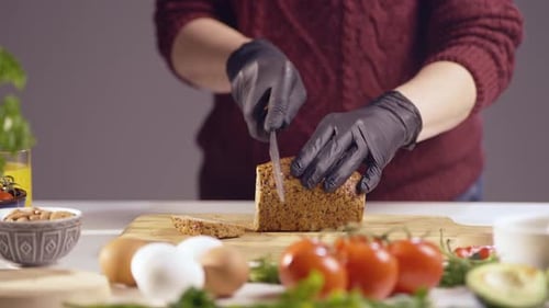 Adult Slices Bread Loaf with Sharp Knife