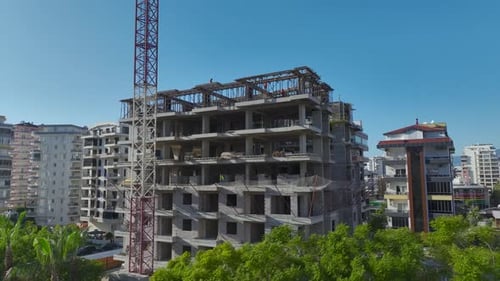 Vídeo aéreo: Se instala una estructura metálica en un edificio de gran altura con trabajadores preparándose para el concreto